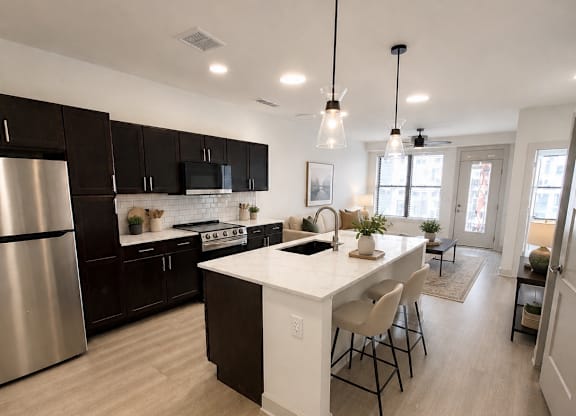 A modern kitchen with a center island and pendant lights.