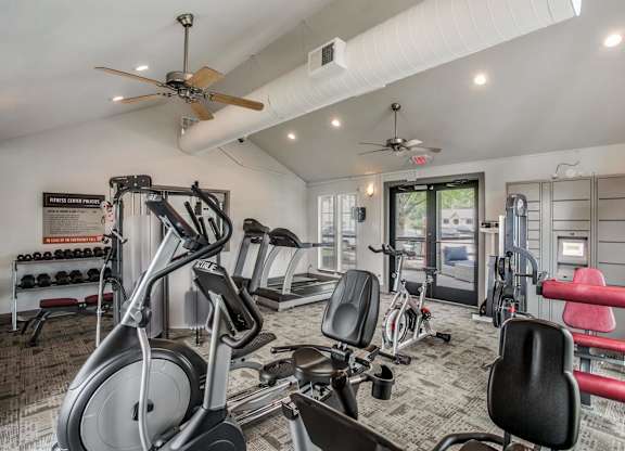 a home gym with exercise equipment and ceiling fans