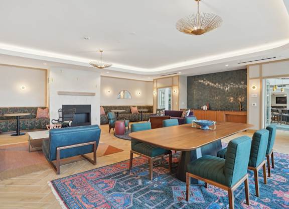 A living room with a blue rug and a wooden table.