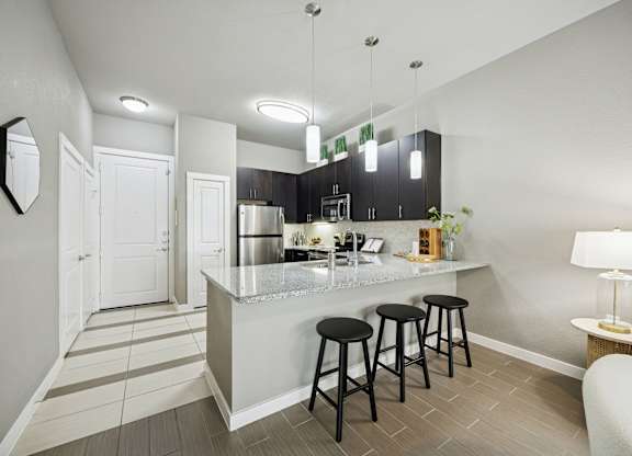 A kitchen with a bar stool and a counter.