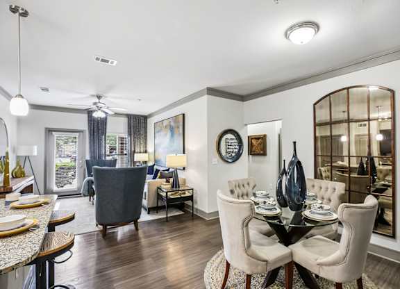 A dining room with a table set for two and a view of the backyard.