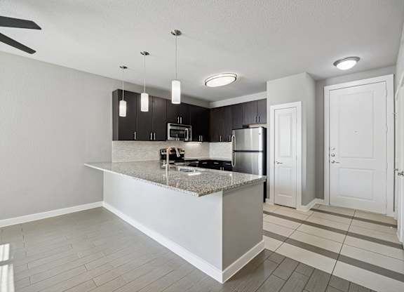 A modern kitchen with a granite countertop and white cabinets.