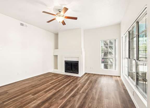 A room with a fireplace and wood flooring.