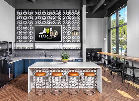 a kitchen with a large center island with stools in front of it at Harper Apartments in St Paul, MN