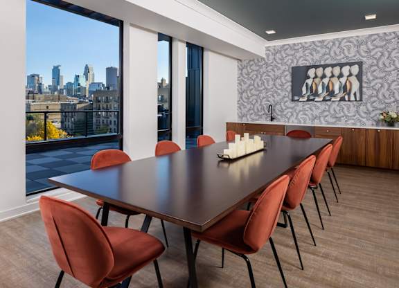a dining room with a table and chairs and a view of the city