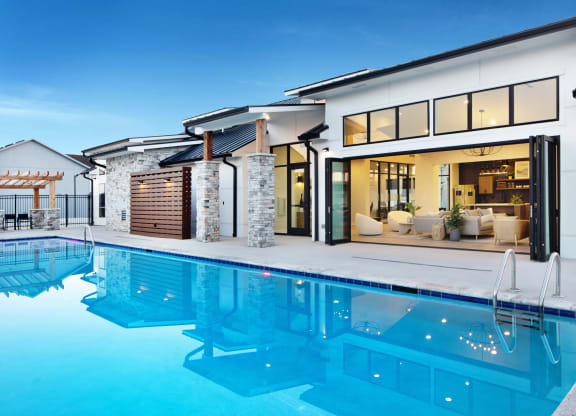 Raymore, MO, Townhomes Near Paradise Park - The Venue Townhomes - Outdoor Resort-Style Swimming Pool with Clubhouse in the Background.