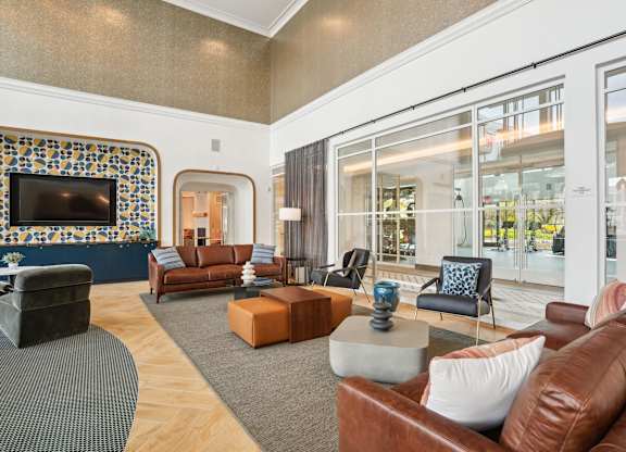 A living room with a brown leather couch and a television.