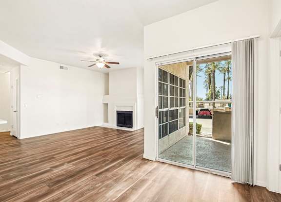 A room with a fireplace and a sliding glass door leading to a balcony.