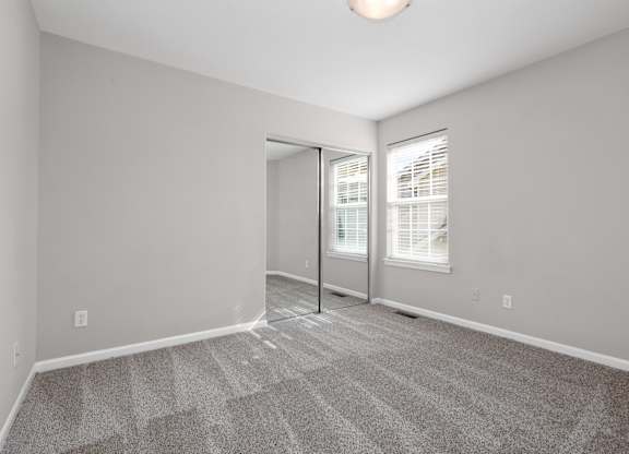 A room with a carpeted floor and a sliding glass door.