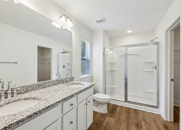 A bathroom with a walk-in shower and a double sink vanity.