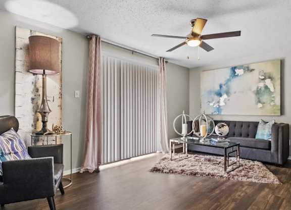 a living room with a ceiling fan and a sliding glass door