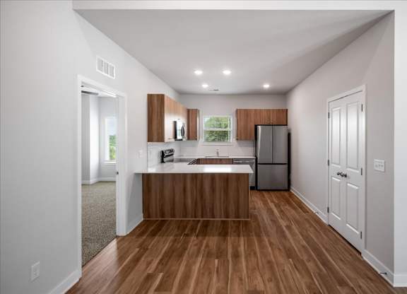 A kitchen with wooden cabinets and a refrigerator.