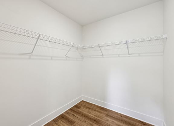 Empty room with white walls and wooden floor.