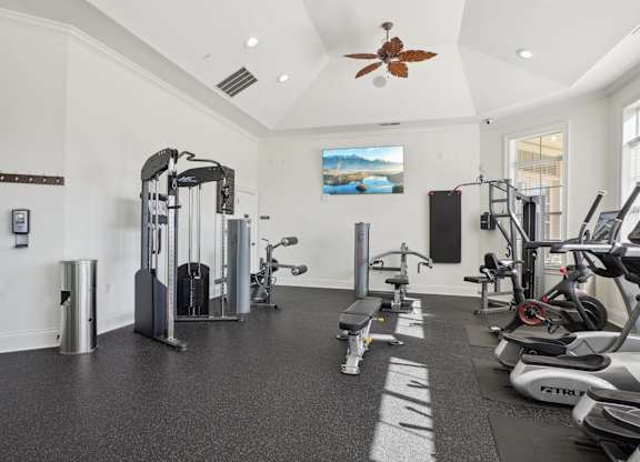A spacious gym with a variety of equipment including treadmills, stationary bikes, and weight machines.