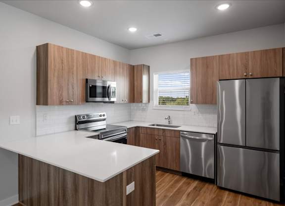 A modern kitchen with wooden cabinets and stainless steel appliances.