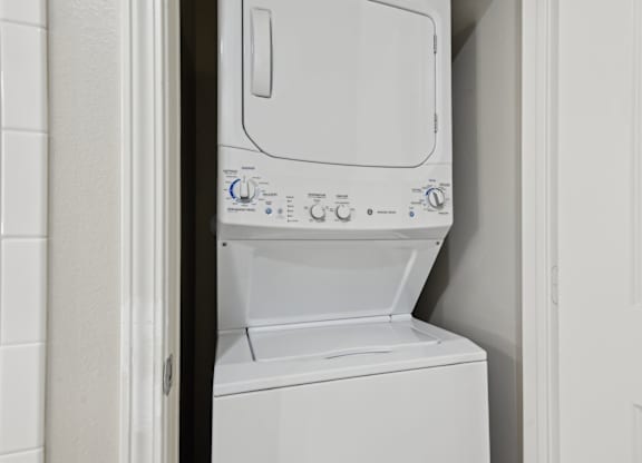 A white dishwasher is open and facing a white door.