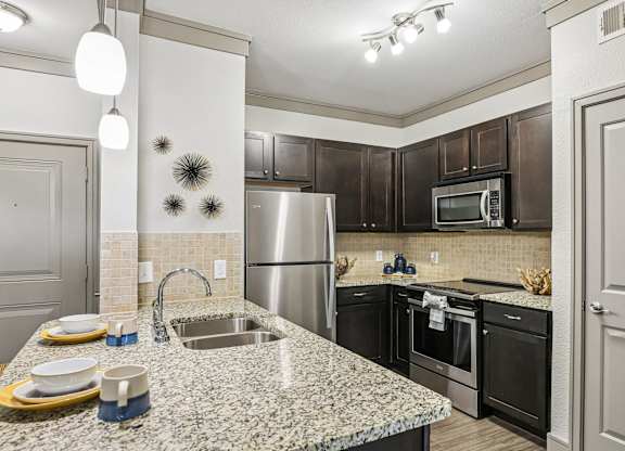 A kitchen with granite countertops and stainless steel appliances.