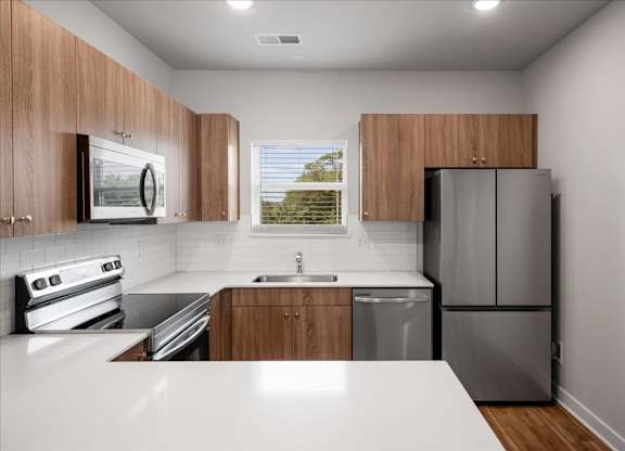 A modern kitchen with wooden cabinets and stainless steel appliances.