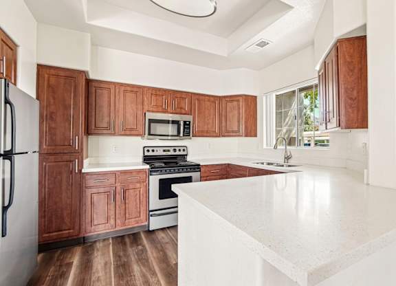 A kitchen with brown cabinets and white countertops.