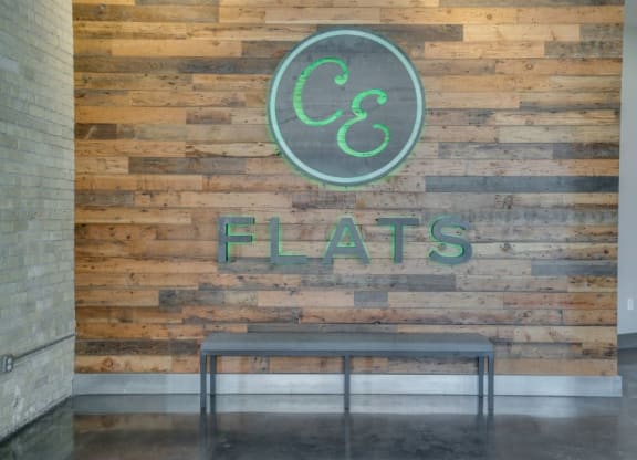 CE Flats logo on wooden wall in lobby C&E Living in St Paul, MN