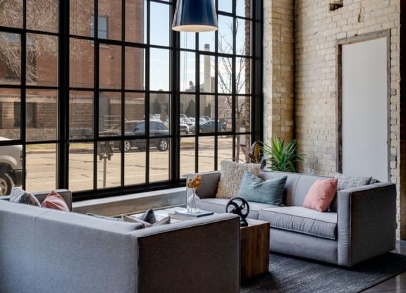 Exposed brick and warehouse windows in restored lobby space C&E Living in St Paul, MN