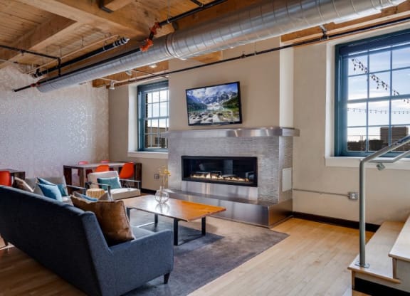Community Room with fireplace and work-from-home seating C&E Living in St Paul, MN