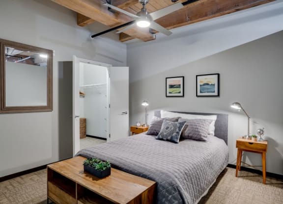Loft style bedroom with exposed wood ceilings and walk-in closet C&E Living in St Paul, MN