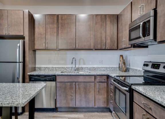 Flats Kitchen with granite countertops and dark wood cabinets C&E Living in St Paul, MN