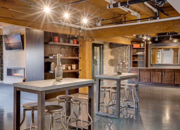 the kitchen and dining area of a loft with a bar and stools