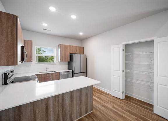 A kitchen with white countertops and wooden cabinets.