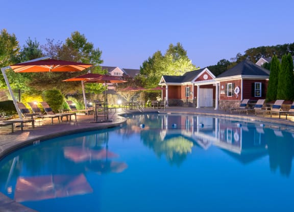 Night view of pool with lounge seating surrounding