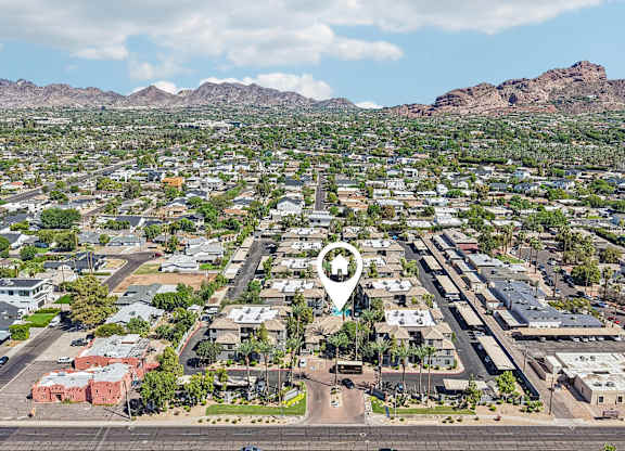 A bird's eye view of a residential area with a road running through the middle.