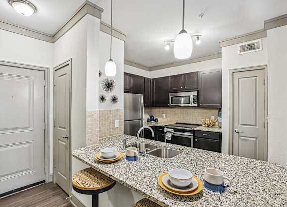 A kitchen with a granite countertop and a sink.