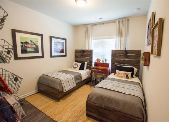 a bedroom with two beds and a table and a window