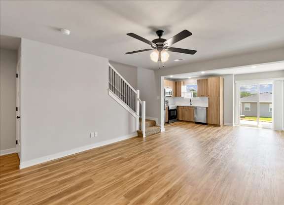 A spacious room with a ceiling fan and wooden flooring.