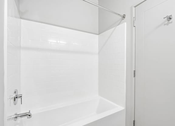 A white bathroom with a tub and shower.