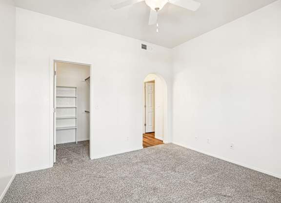 A room with a ceiling fan and a carpeted floor.