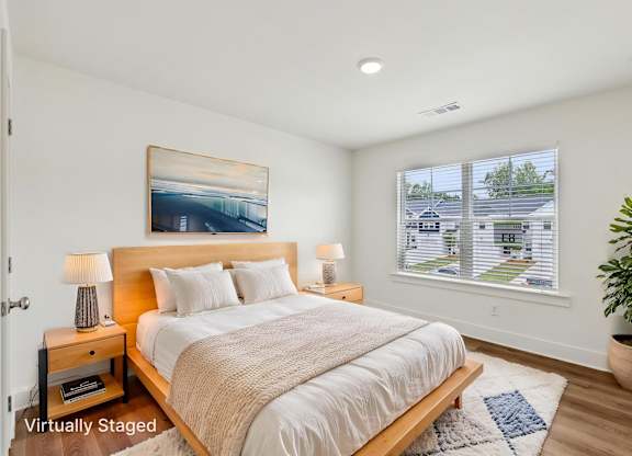 A bedroom with a large bed and a painting on the wall.