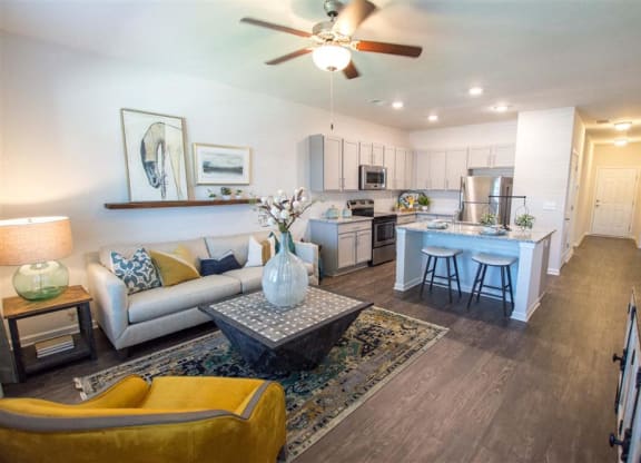a living room and kitchen with a ceiling fan