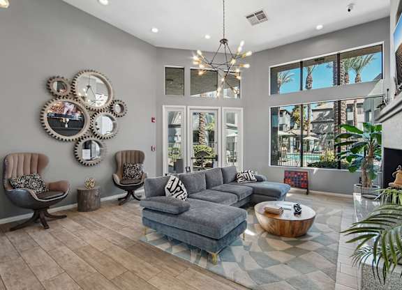 A living room with a grey couch and a fireplace.
