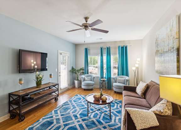 a living room with blue walls and a ceiling fan
