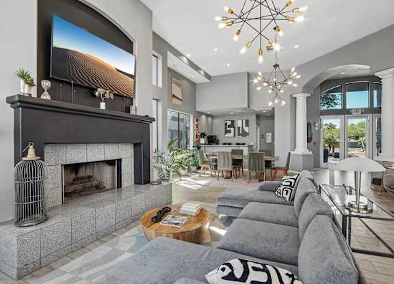 A modern living room with a fireplace and a large TV above it.
