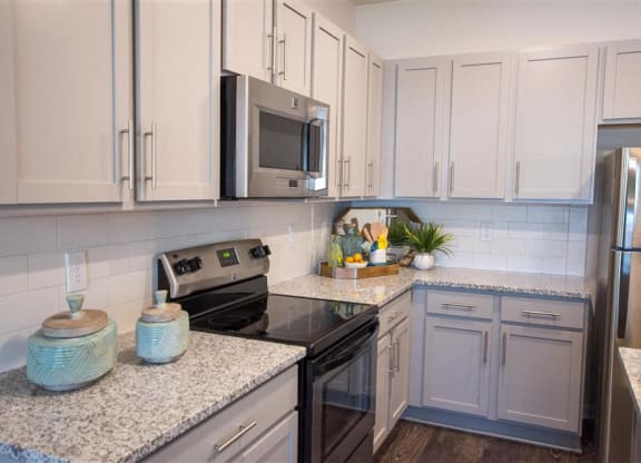 a kitchen with white cabinets and a black stove
