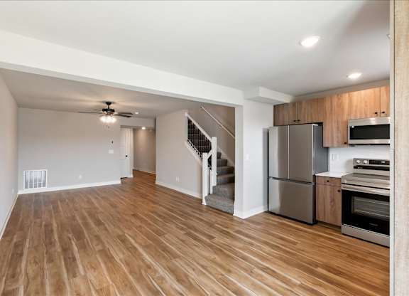 A spacious kitchen with wooden floors and stainless steel appliances.