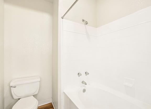 A white toilet and bathtub in a bathroom.