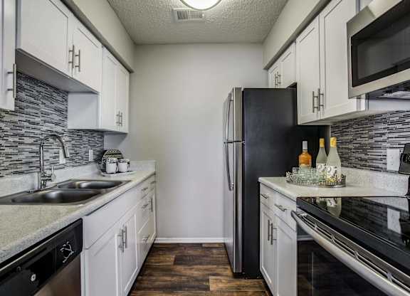 a kitchen with stainless steel appliances and white cabinets
