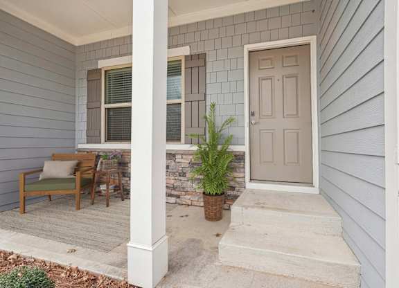 A house with a grey front porch and a white door.