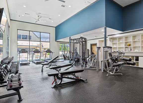 A gym with a variety of equipment including weights and cardio machines.