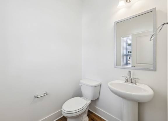 A white toilet and sink in a bathroom.