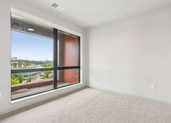 A room with a large window and a sliding door.